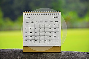 May 2024 white calendar with green blurred background.