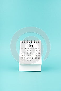 May 2024 white desk calendar on blue background