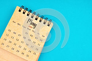 May 2024 white desk calendar on blue background