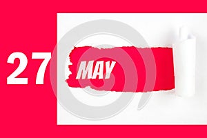 May 27th. Day 27 of month, Calendar date. Red Hole in the white paper with torn sides with calendar date. Spring month, day of the