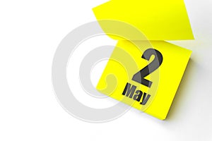 May 2nd. Day 2 of month, Calendar date. Close-Up Blank Yellow paper reminder sticky note on White Background. Spring month, day of