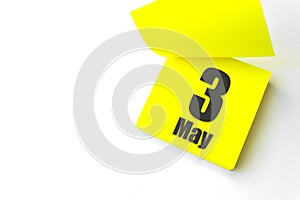 May 3rd. Day 3 of month, Calendar date. Close-Up Blank Yellow paper reminder sticky note on White Background. Spring month, day of