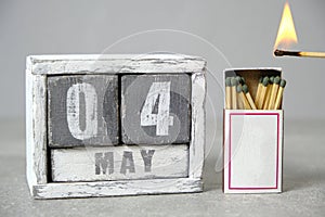 May 4 calendar.Open box of matches and an open flame held up to it.Concept for International Day Firefighters.