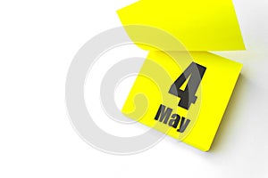 May 4th. Day 4 of month, Calendar date. Close-Up Blank Yellow paper reminder sticky note on White Background. Spring month, day of