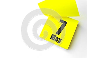 May 7th. Day 7 of month, Calendar date. Close-Up Blank Yellow paper reminder sticky note on White Background. Spring month, day of