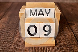 May 9 displayed wooden letter blocks on white background