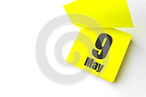 May 9th. Day 9 of month, Calendar date. Close-Up Blank Yellow paper reminder sticky note on White Background. Spring month, day of
