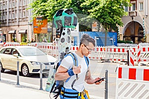 Young man from google corporation is working with huge backpack with 3D panoramic camera used for