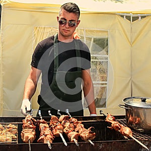 May 23, 2015 Chisinau, Moldova. Young man fry a shish kebab and chicken barbecue outdoors