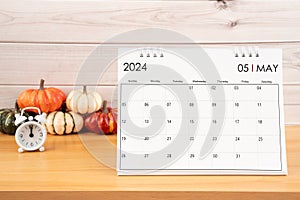 May Desktop calendar for 2024 year and heap pumpkins with clock