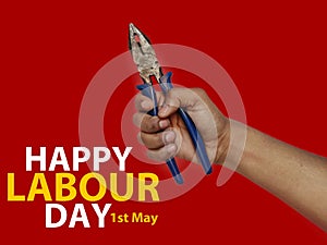 May first International Workers Day. International Workers Day with pliers in hand on Red background