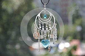 May the luck be with you. Luck amulet hung out outdoor. Name amulet for good luck. Silver amulet with gems and pendants. Believing