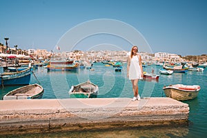 Beautiful view on the traditional eyed colorful boats Luzzu in the Harbor of Mediterranean fishing village Marsaxlokk, Malta