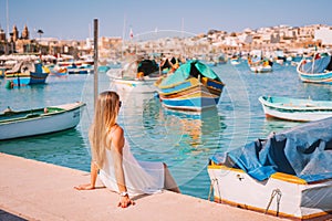 Beautiful view on the traditional eyed colorful boats Luzzu in the Harbor of Mediterranean fishing village Marsaxlokk, Malta