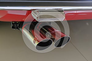May 2022 Modena, Italy: Chrome plated exhaust pipe close-up of the Ferrari sportscar car. Ferrari logo icon