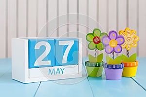 May 27th. Image of may 27 wooden color calendar on white background with flowers. Spring day, empty space for text photo