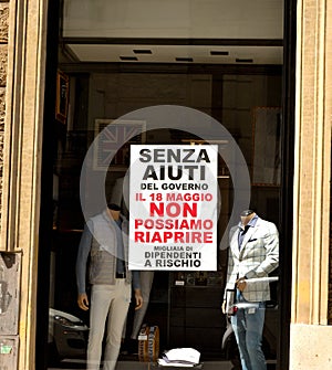 Closeup of a shop window in the historic center of Rome with a protest sign for the economic crisis resulting from the lockdown