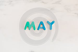 May word written with colorful letters on white marble stone background