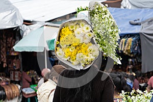 A Mayan woman is carrying on her head bouquets of flowers at the Chichicastenango market in Guatemala.