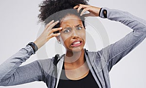 Maybe Im being paranoid but...Studio shot of a young woman making a funny face against a gray background.