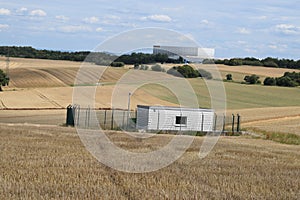 Mayen, Germany - 07 27 2020: water supply plant between grain fields with logistics center in background