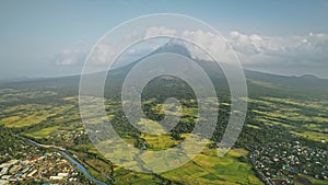 Mayon volcano erupts at Philippines countryside aerial. Tropic green forest plants and grasses