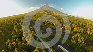 Mayon Volcano near Legazpi city in Philippines. Aerial view over the palm jungle and plantation at sunset. Mayon Volcano