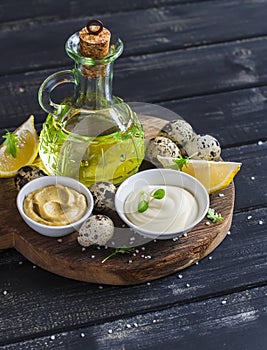 Mayonnaise and ingredients for cooking - olive oil, quail eggs. lemon, mustard and spices