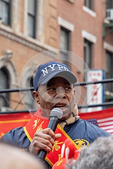 Mayor Eric Adams standing on a stage in front of an audience engaging them with a speech