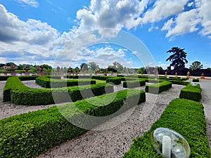 Maze made of small hedgerow in park during beautiful summer weather