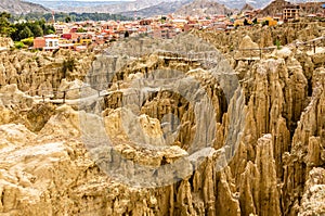 Maze of Moon Valley or Valle De La Luna  eroded sandstone spikes, with La Paz city suburb in the background, Bolivia