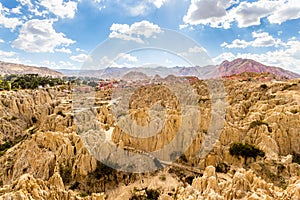 Maze of Moon Valley or Valle De La Luna  eroded sandstone spikes, with La Paz city suburb and mountains in the background, Bolivia