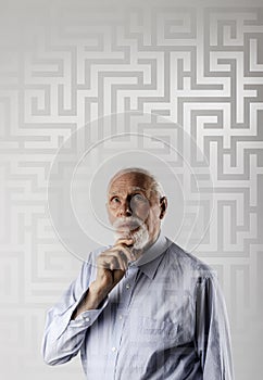 Maze. Old man is solving a problem. Old man is full of doubts