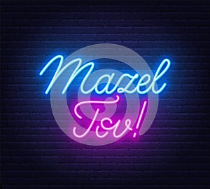 Mazel Tov neon lettering on brick wall background.