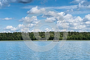 Mazury Lakes view with sailing boat at midday photo