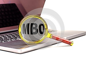 MBO word on magnifier on laptop , white background photo