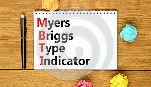 MBTI Myers Briggs type indicator symbol. Concept words MBTI Myers Briggs type indicator on white note on beautiful wooden