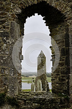 McCarthy's Tower seen through a cathedral window in the medieval monastery of Clonmacnoise, during a rainy summer day