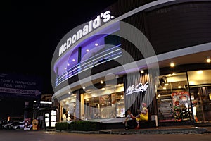 McDonald`s fast food restaurant and McCafe coffee shop on night view at Porto Chino Community Market