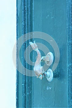 Mdina, Malta, July 2014. Old dolphin doorknob on a blue wooden door.