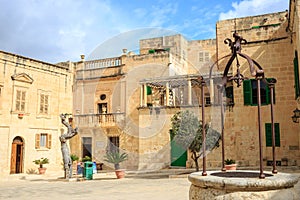 Mdina, Malta. Well at Misrah Mesquita square and traditional facade buildings background.