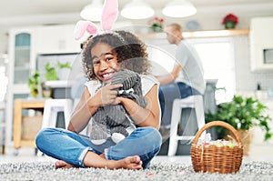 Me Egg-cited How can you tell. a young girl sitting on the floor with easter eggs at home.