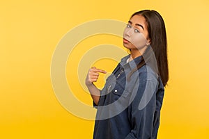 This is me! Portrait of arrogant selfish girl in denim shirt proudly pointing herself, boasting of success, feeling supercilious photo