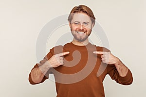 This is me! Portrait of happy egoistic selfish man with beard in sweatshirt pointing himself, feeling proud and ambitious