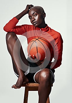 Me time is ball time. Studio shot of an attractive young woman playing basketball against a grey background.