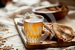 Mead and pancakes. Russian dish for Shrove Tuesday. Farewell to winter, Close a glass with a glowing drink. photo