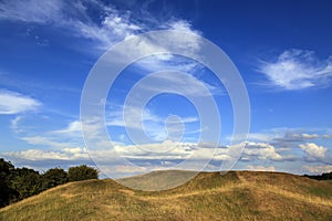 Meadow and blue sky with clouds