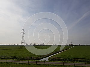 Meadow with brook and high voltage power lines