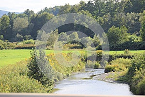 A meadow with a brook running through it