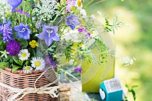 Meadow flowers bouquet in wicker mug on nature background outdoors in natural morning light, still life with vivid wild flowers in